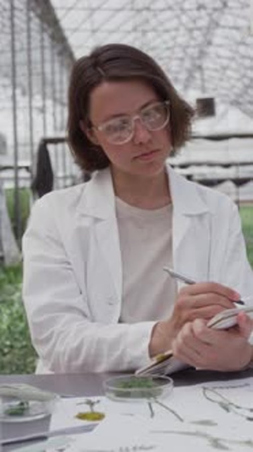 Portrait of Female Plant Scientist Working in Greenhouse Laboratory