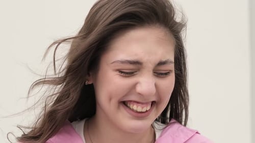 Con una expresión dramática de dolor, la mujer encarna la alegría de representar sus emociones