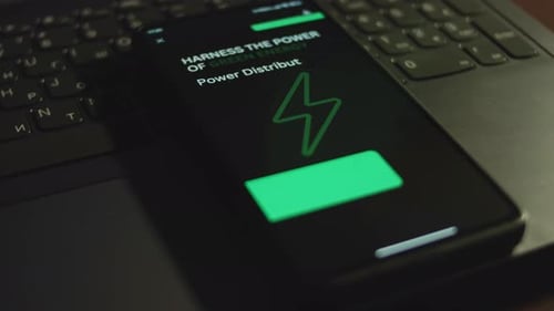 Mobile Phone Displaying Green Energy Graphic on Laptop