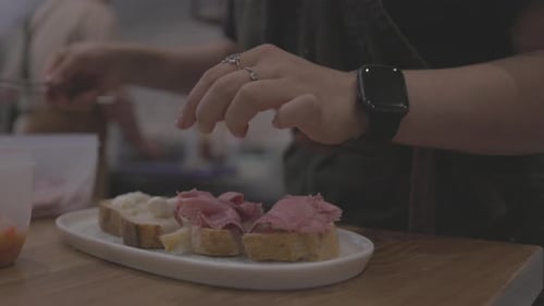 Preparing Small Open Sandwiches on a Wooden Table