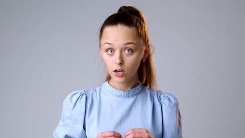 Young Woman Smiling on Gray Studio Background