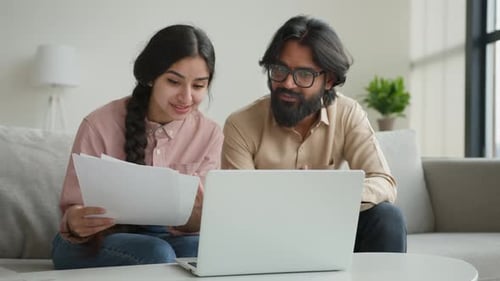 Indian Couple Use Laptop Read Bank Papers Bills Pay Online at Home Arabian Husband Man and Wife