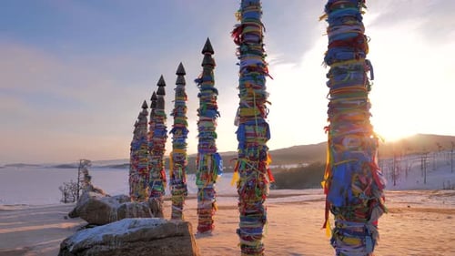 Pilares rituais sagrados com fitas coloridas no Cabo Burkhan, Ilha Olkhon, Lago Baikal, ao amanhecer em