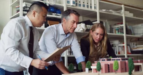 In Modern, Industrial Office, Group of Architects Discuss a Scale Model And