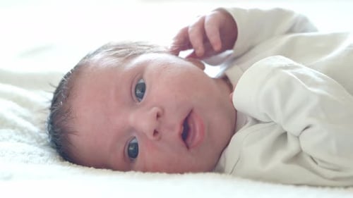 Adorable Infant Lying on White Blanket