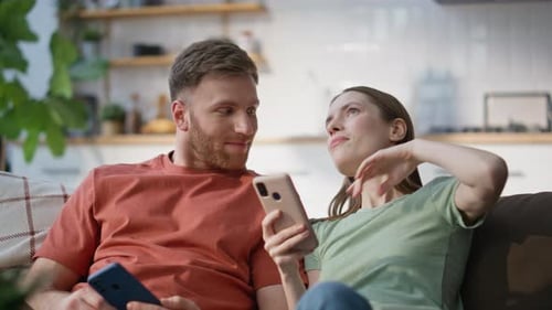 Couple Relaxing on Couch Using Smartphones Together