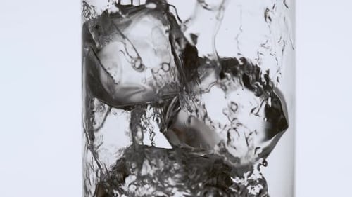 Beverage Being Poured into a Glass with Ice Cubes