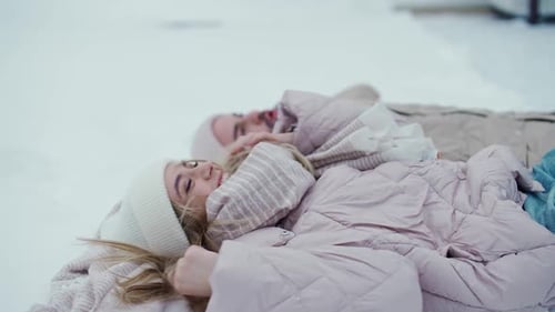 Couple Lying Together in Snowy Winter Landscape