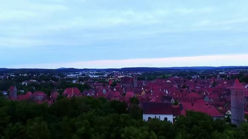 a drone rises over the ancient city in the evening aerial view red roofs of country houses