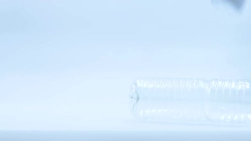 Three plastic bottles, empty and recyclable, dropping at real speed on a white background and stabil