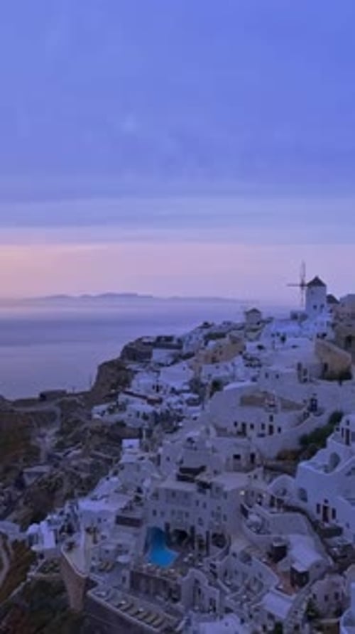 Famous Oia village in Santorini, Greece, at violet sunset - panning