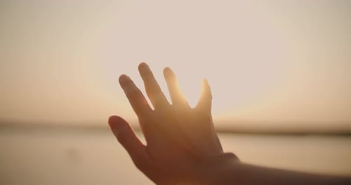 Weibliche Hand, die sich der Sonne nähert