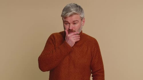 Man Coughing and Massaging Head on Plain Backdrop