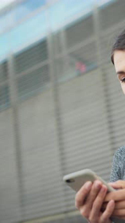 Smiling Woman Using Mobile Phone in City