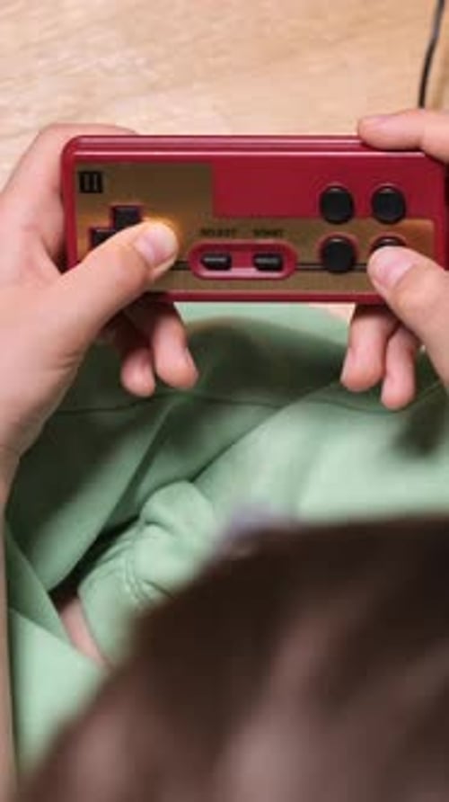 Person Plays Video Game on Handheld Console