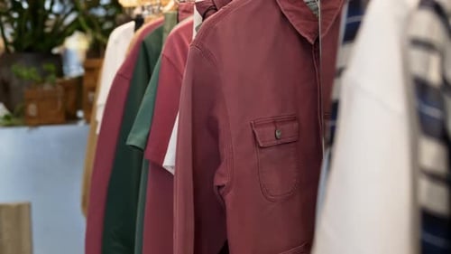 Close up of multiple clothes hanging on a rack in a hipster clothing store