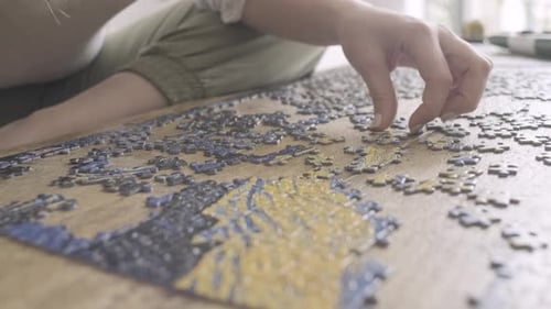woman solving a Jigsaw puzzle in Quarantine. Female hands Close up