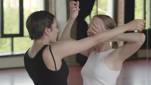 Women Practice Synchronized Arm Movements in Dance Studio