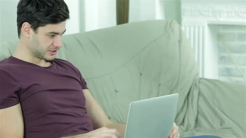 Couple Relaxing at Home with Laptop and Mug
