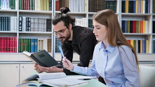 Teenager-Studentin lernt mit männlichem Lehrer in der Klassenbibliothek