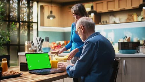 Chroma Key Laptop with Retired Man Checking Display at the Table in Rustic Kitchen