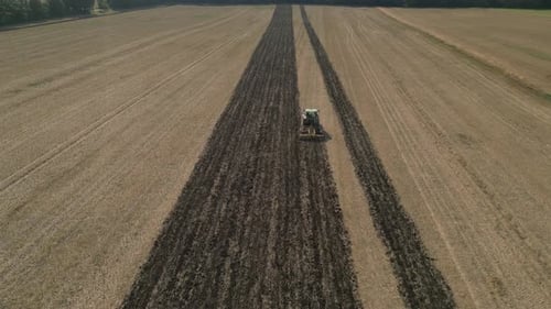 Aerial View Of Tractor Plowing Agricultural Farm Field - Drone Shot