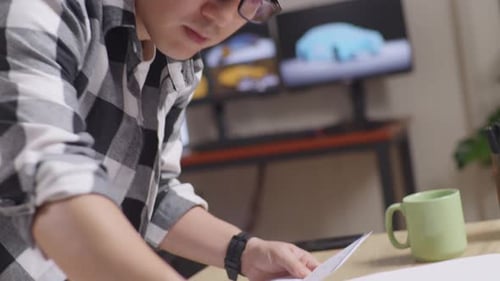 Close Up Of Male Organizing Papers While Working About Car Design Sketch On Table In The Studio