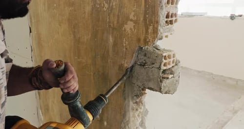 Poderoso primer plano de manos masculinas que operan un martillo de demolición