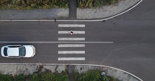 A Car Gives Way to a Person at a Pedestrian Crossing