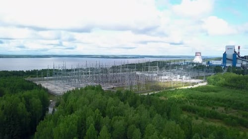 Power Plant Generating Electricity Near River and Forest