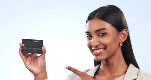 Happy woman, credit card and pointing for banking, payment or advertising against a blue background