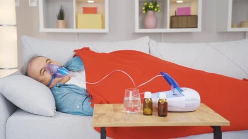 Vieil homme utilisant un respirateur.