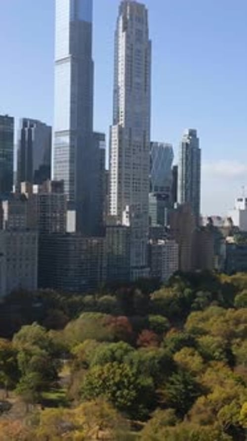 Vertical drone shot over central park, toward Billionaires' Row, fall in New York