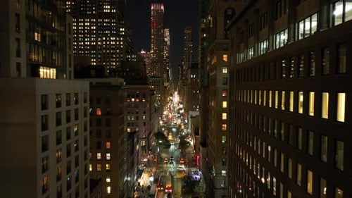 Cars Drive on a Busy Midtown Manhattan Street in New York City at Night Apartment Windows
