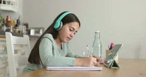 Girl learning online using tablet and headphones