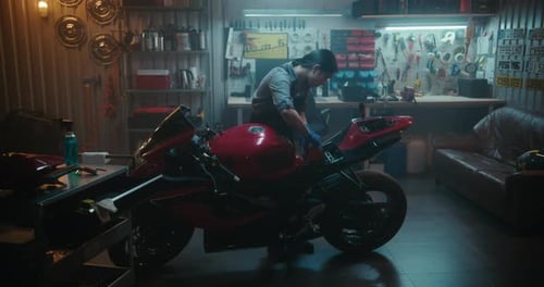 Une femme prend la batterie de la moto, la place dans le compartiment et reconnecte les bornes
