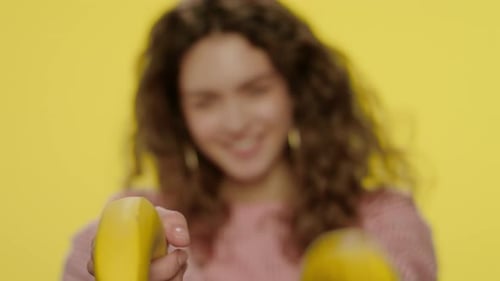 Playful Woman with Banana Gun in Studio