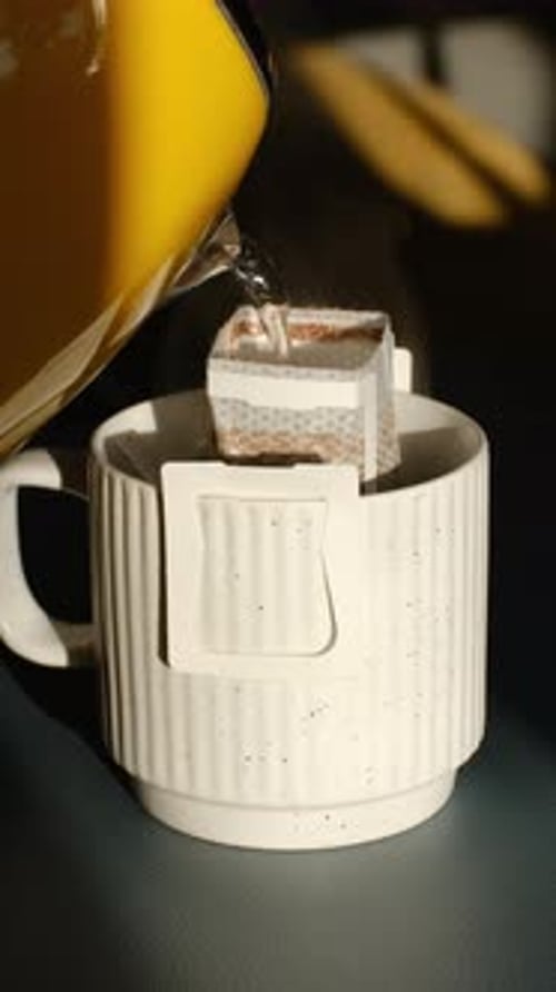 Making drip coffee in a white speckled mug