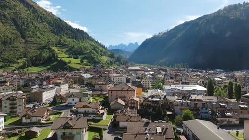 Slow aerial footage of a quaint Italian town nestled in a valley in the Dolomites.