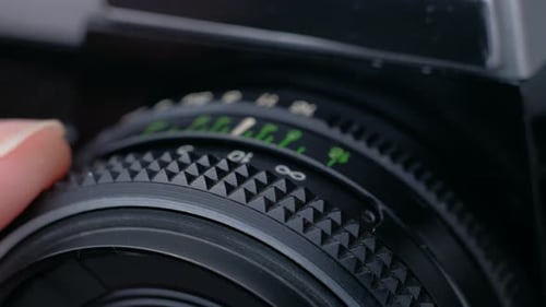 Finger Adjusting Focus on Vintage Camera Lens