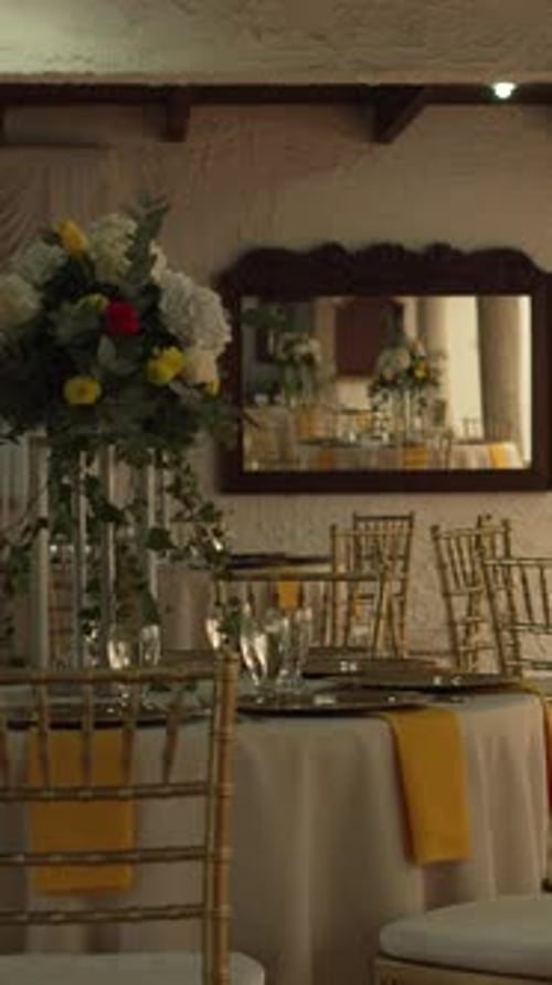 Hall with tables decorated for wedding reception with fresh flowers. Banquet table. Vertical.