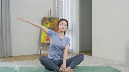Calm spiritual young woman female doing physical exercises in apartment, practicing yoga, stretching