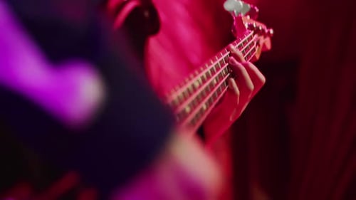 A Closeup of a Musician Playing an Electric Guitar Passionately and Quickly Plucking Strings