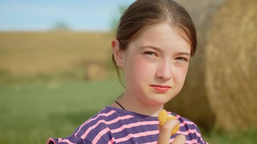 Child Eats Chicken Nugget Near Hay Bales