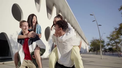 Centennials Friends on Vacation Having Piggyback and Stacking Hands on City Street Young People
