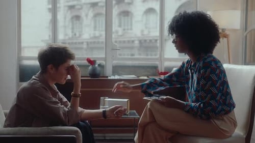 Concerned Adults Comforting One Another in Bright Room