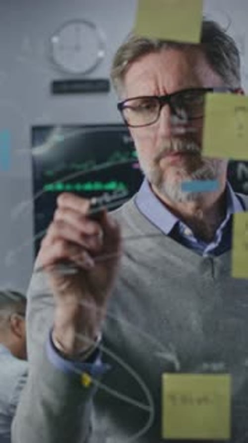 Man Brainstorming at Clear Board in Office