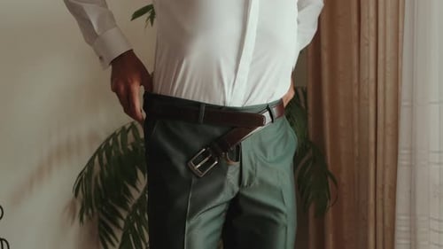 Man Fastening Brown Belt, Preparing For a Wedding
