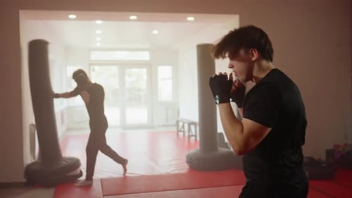 Athlete Wearing Black Sportswear Practices Boxing Techniques Inside Training Gym