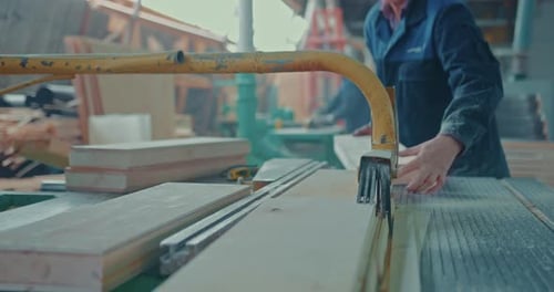 Worker Operating Table Saw in Woodworking Workshop